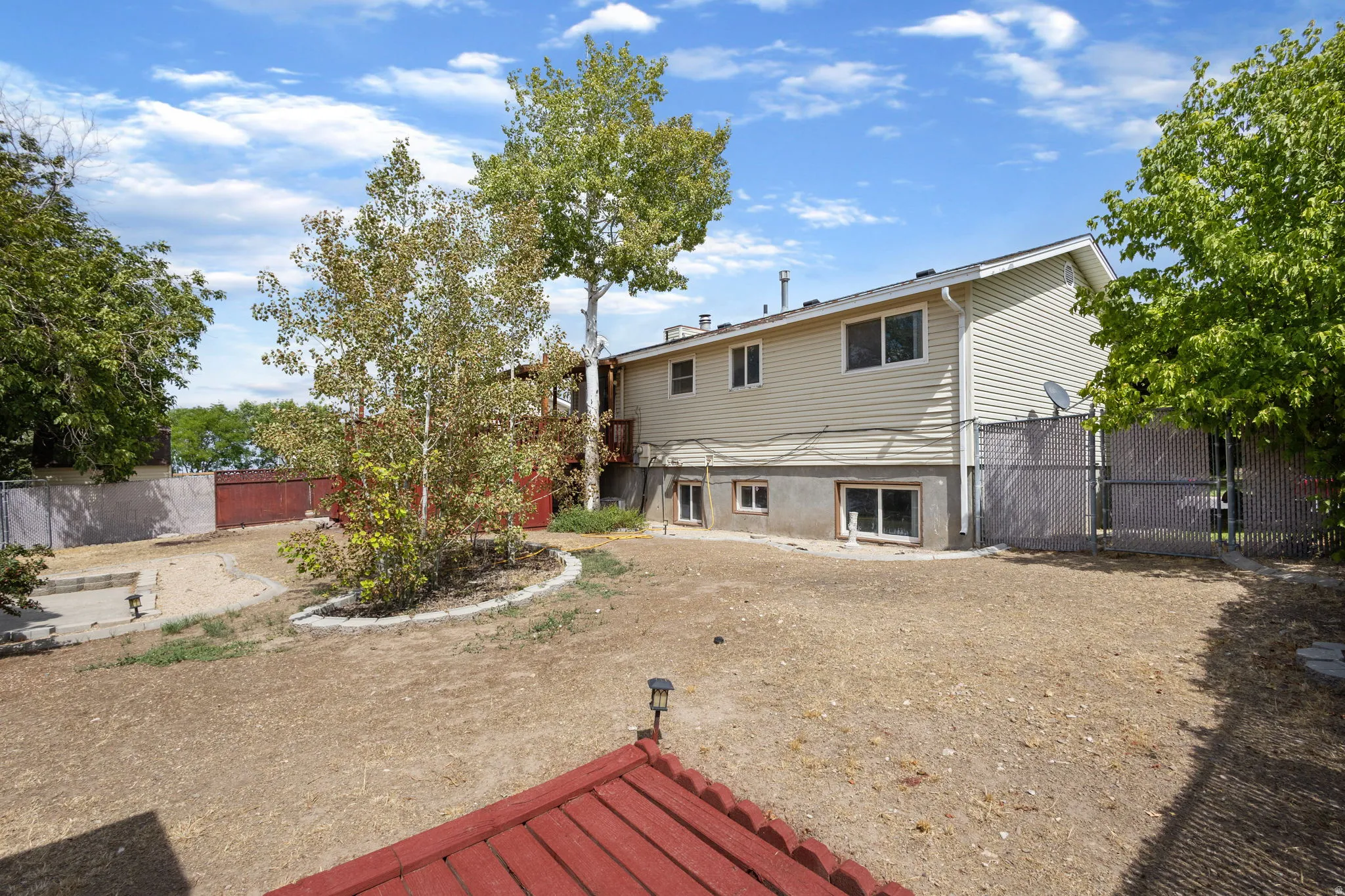 Spacious backyard with mature trees and a fenced perimeter