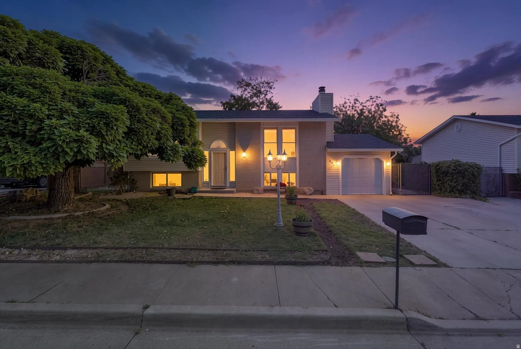 Split-level residence featuring a brick facade, attached single-car garage, and a concrete driveway