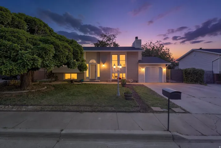 Split-level residence featuring a brick facade, attached single-car garage, and a concrete driveway