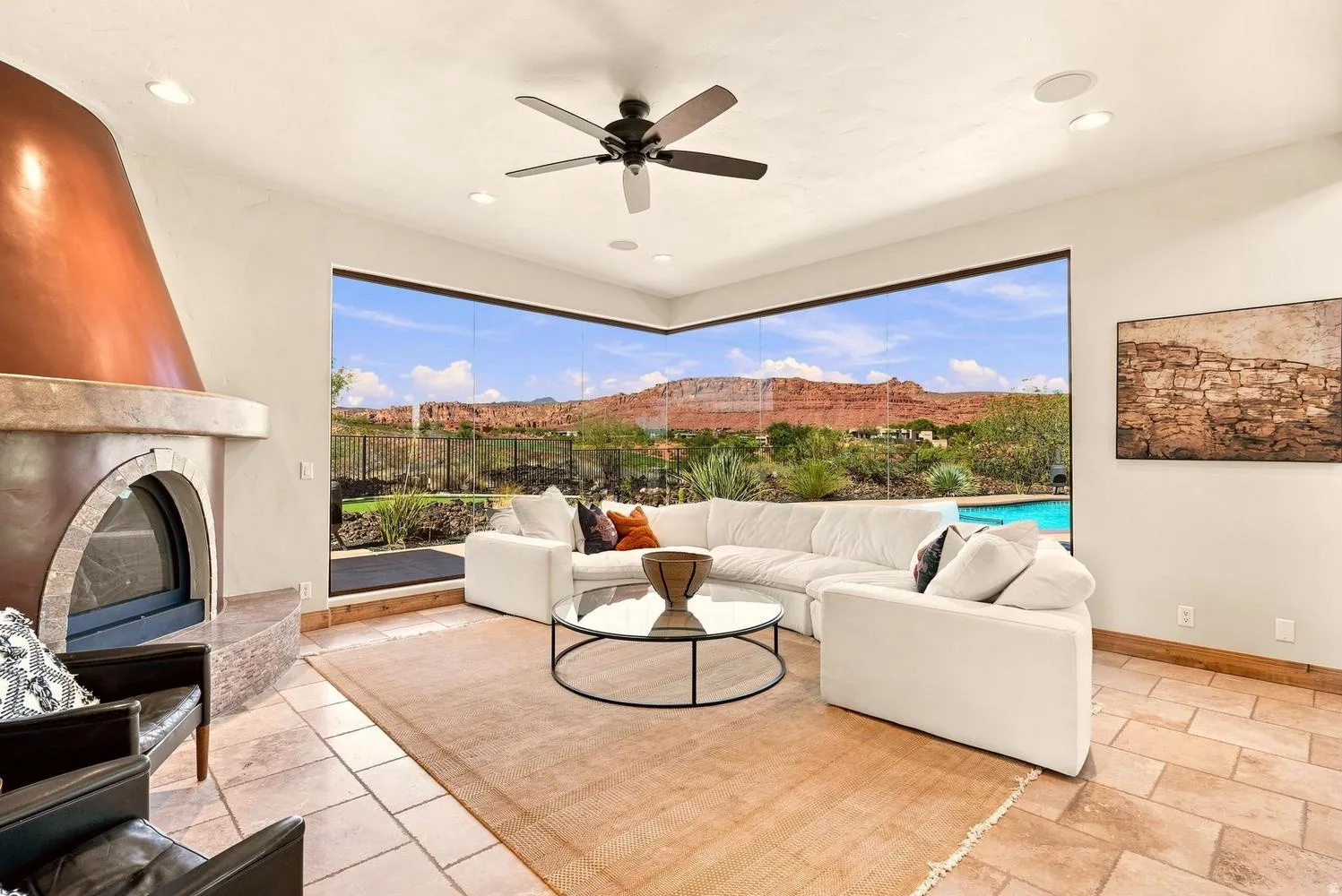 Expansive glass wall, custom fireplace with copper hood, tiled flooring, recessed lighting, and a ceiling fan