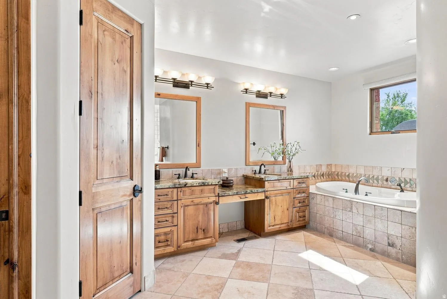 Dual wood-finish vanities with undermount sinks and dark fixtures