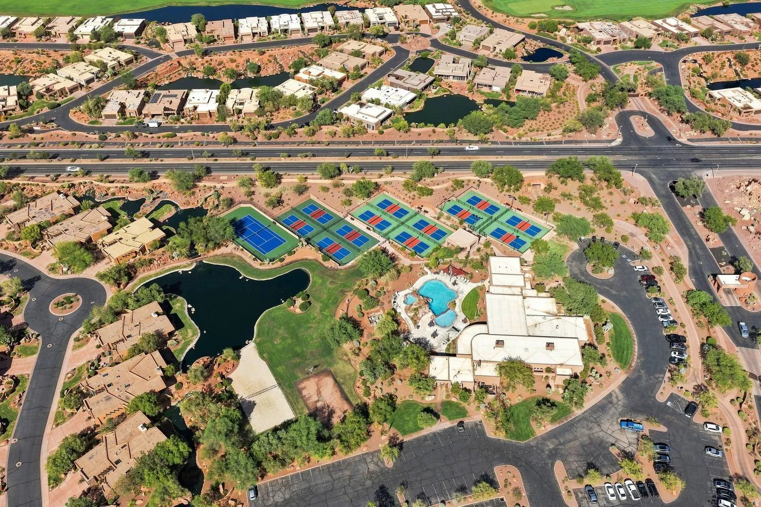 Expansive community featuring multiple tennis courts, a large swimming pool, and a clubhouse