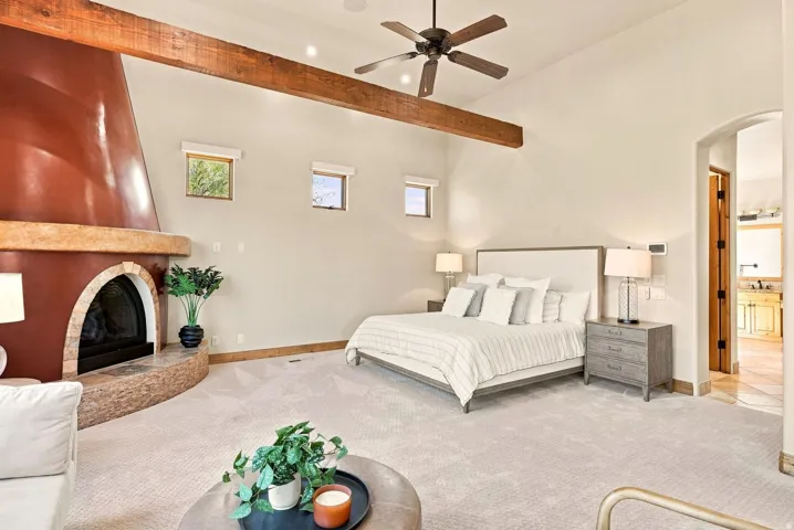 Vaulted ceiling with exposed wood beam, ceiling fan, and recessed lighting
