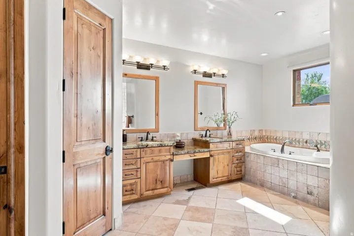 Dual wood-finish vanities with undermount sinks and dark fixtures