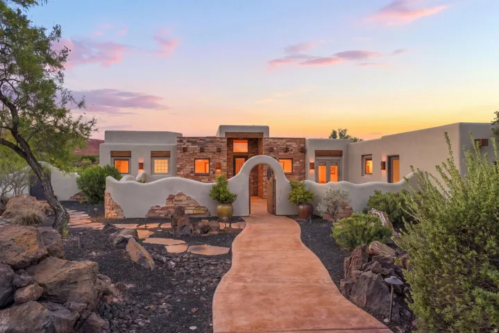 Stucco exterior with stone accents, arched entryway, and a winding stone pathway