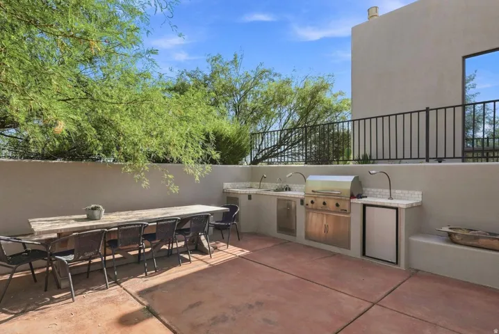 Outdoor entertaining area featuring a built-in grill, dual sinks, and a refrigerator