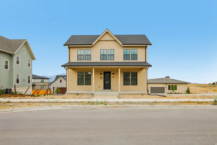 Two-story residence with a covered front porch and a dark wood-finish entry door