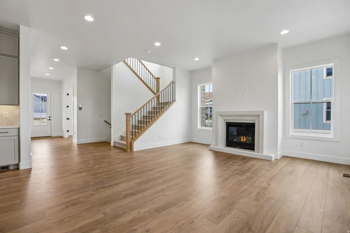 Wood-finish flooring throughout, featuring a staircase with wood newel posts and metal balusters