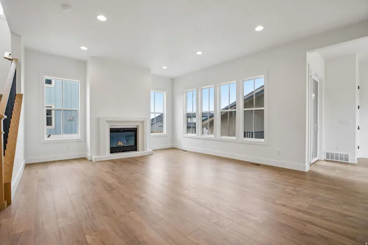 Recessed lighting, wood-finish flooring, and a fireplace with a mantel