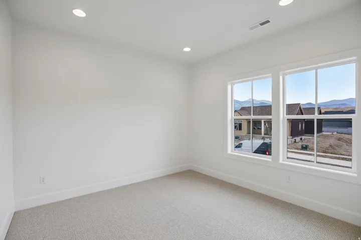 Neutral wall color, recessed lighting, double-hung windows, and carpet flooring