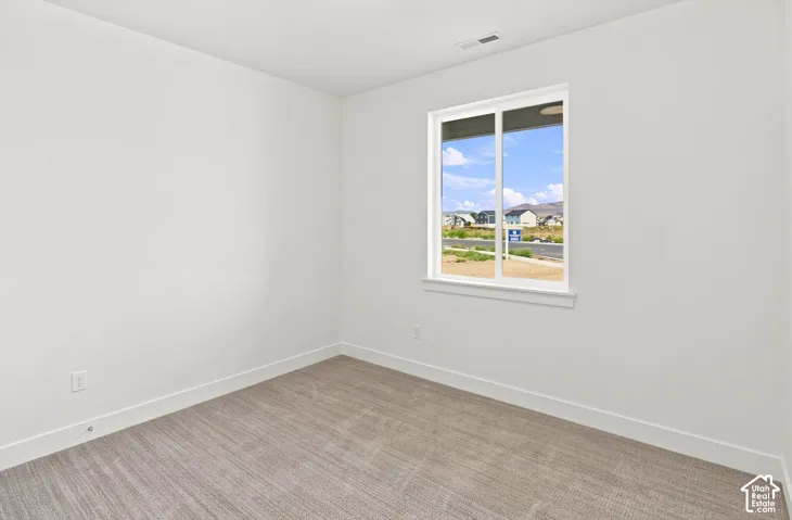 Carpeted interior with light-toned walls and a single window