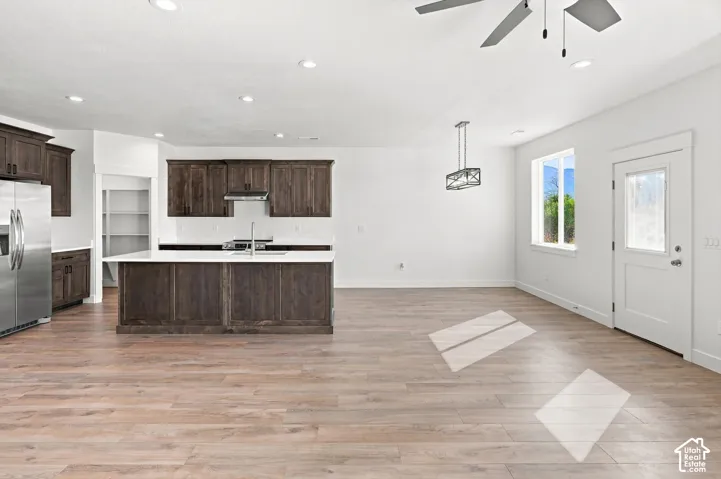Expansive open-concept space featuring wood-finish flooring, recessed lighting, white walls, and a modern ceiling fan