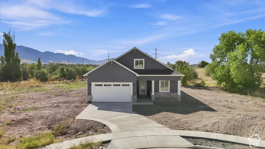 Single-story residence featuring a dark gray exterior, white trim details, and a stone facade accent