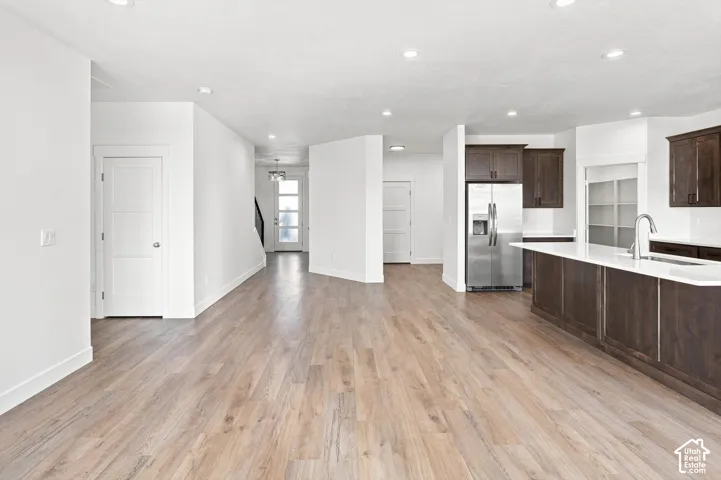 Open-concept living area featuring wood-finish flooring, recessed lighting, and white walls