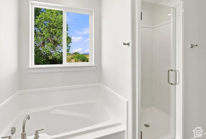 Built-in soaking tub with brushed nickel fixtures and a white framed window