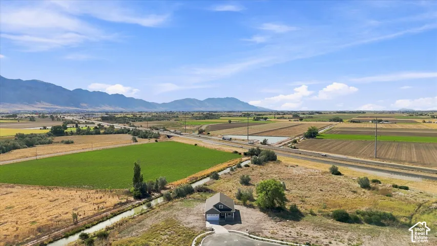 Expansive agricultural landscape with distant mountains under a blue sky
