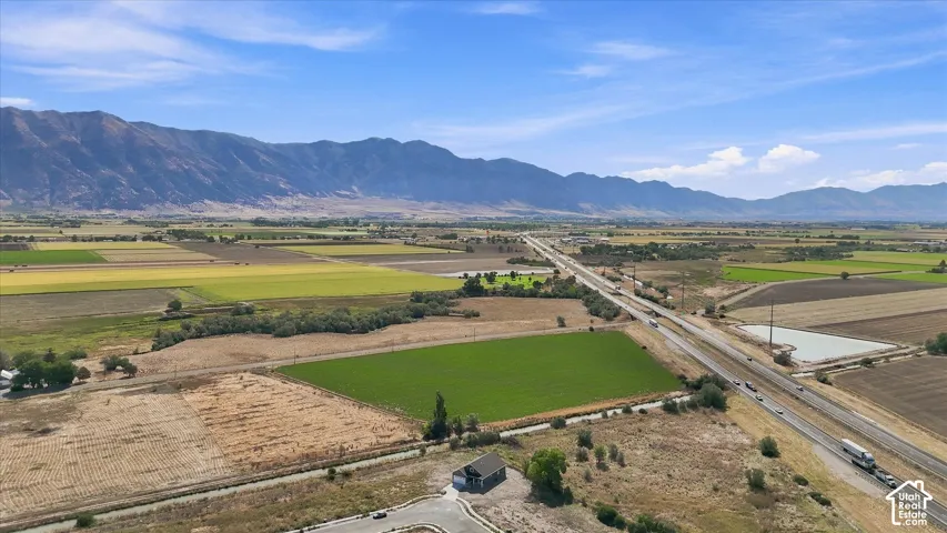 Expansive rural setting with a highway, cultivated fields, and distant mountains