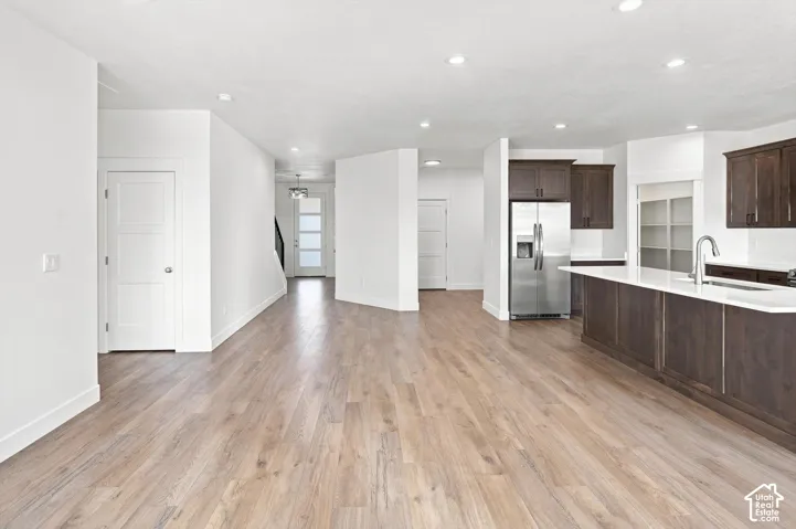Wood-finish flooring, recessed lighting, white walls, dark wood-finish cabinetry, and stainless steel appliances