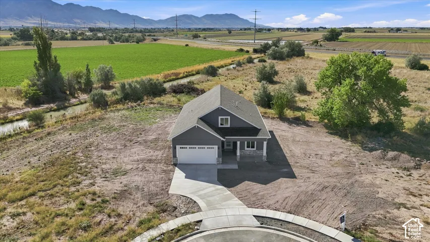 Newly constructed residence with a gray siding exterior, an attached garage, and a concrete driveway