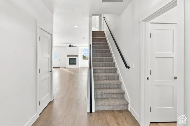 Carpeted staircase with a black handrail