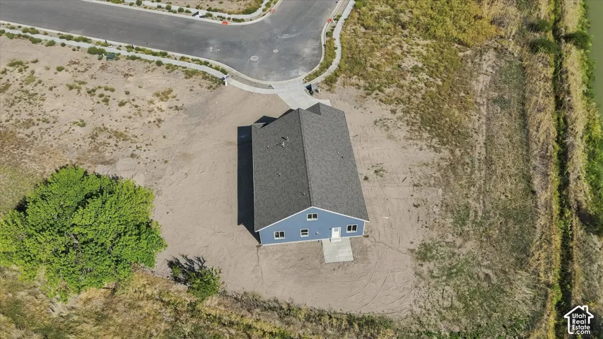 Blue exterior siding with white trim, dark shingle roof, and concrete entrance pad