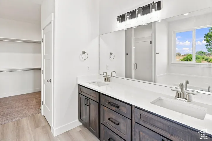 Double vanity with integrated rectangular sinks, modern dark wood-finish cabinetry, sleek hardware, and a large mirror