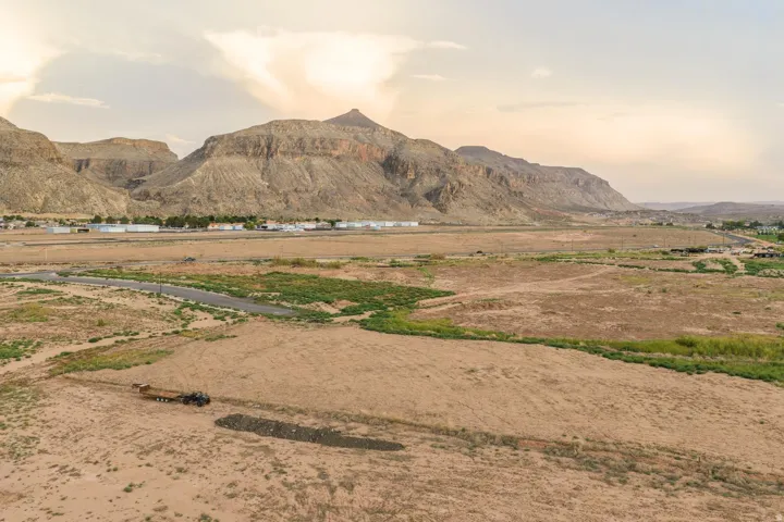 Expansive land parcel with surrounding mountains and distant structures