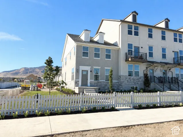 Contemporary townhome exterior featuring stucco and stone-finish siding