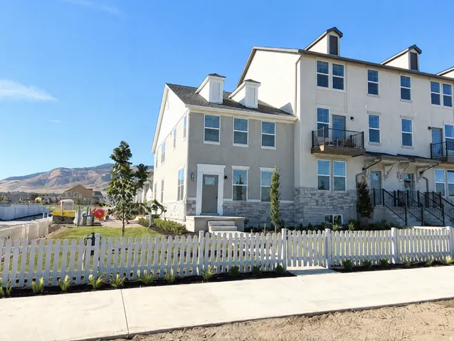Contemporary townhome exterior featuring stucco and stone-finish siding