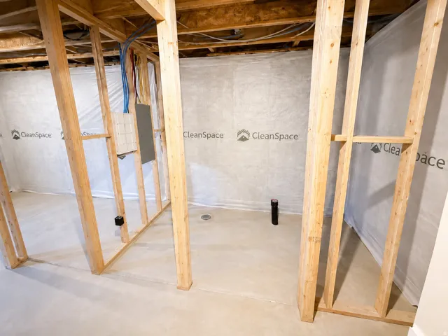 Unfinished basement featuring wood framing and concrete flooring