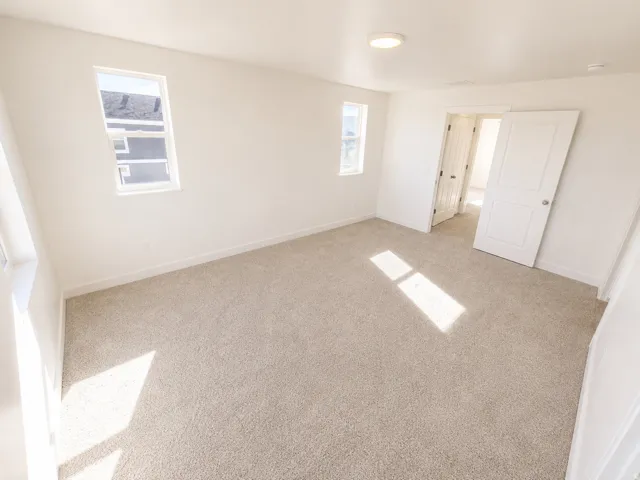 Recessed ceiling light, neutral carpeting, white walls, and white trim