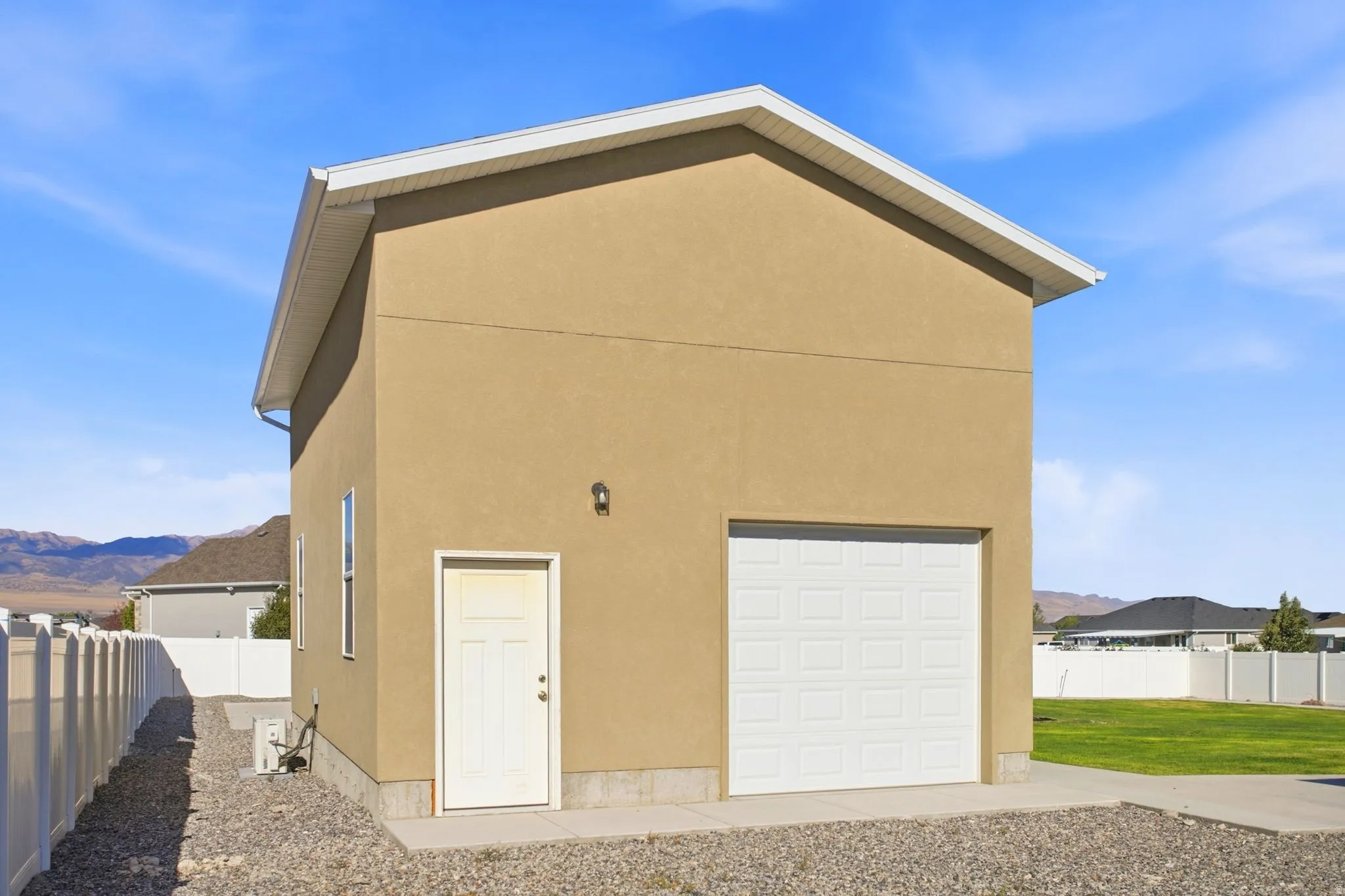 Detached two-story auxiliary building featuring a single garage door.