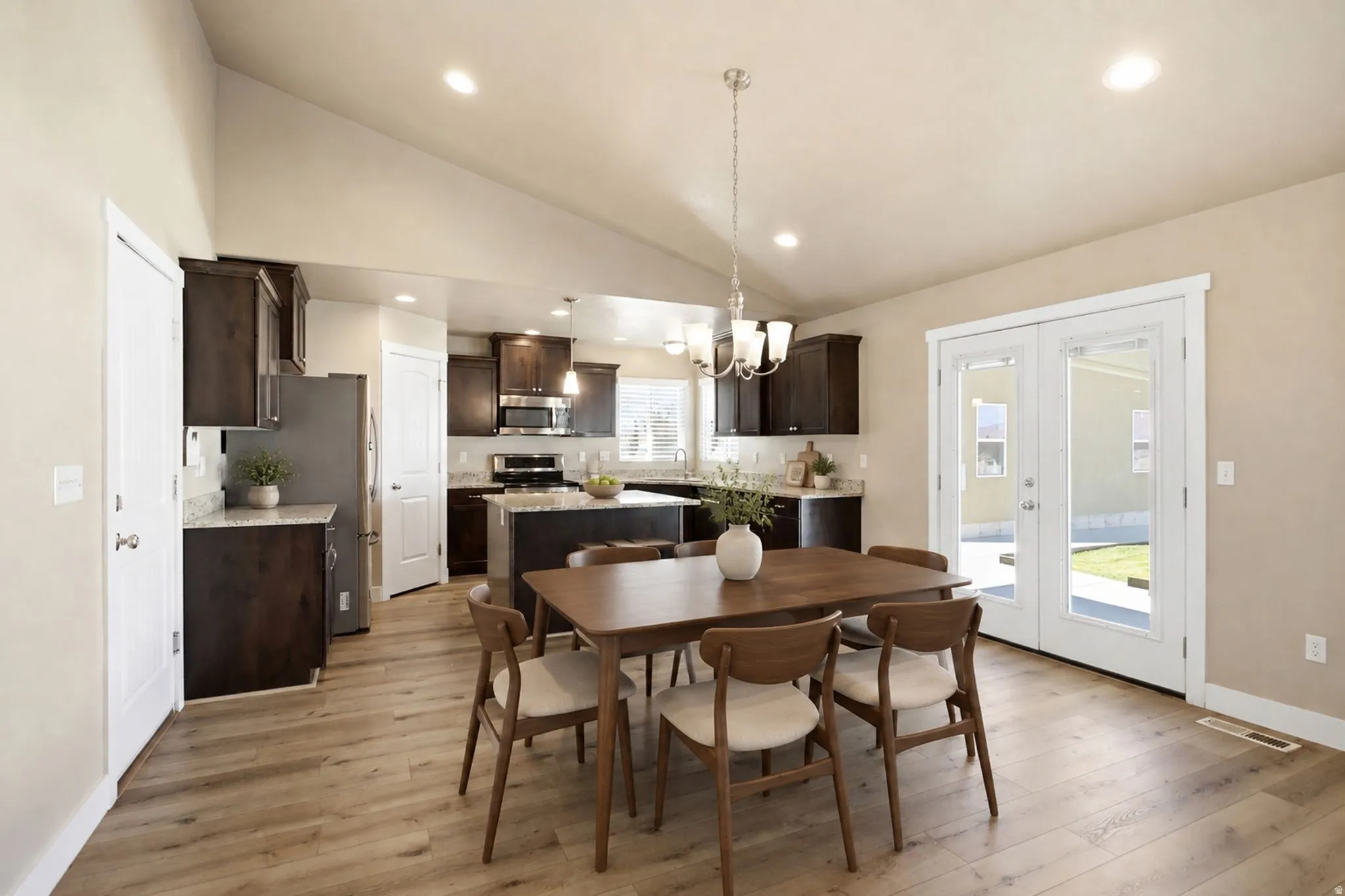 Open-concept living area with vaulted ceilings and access to yard area.