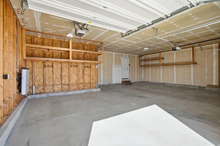 Spacious garage with built-in shelving and garage door openers.