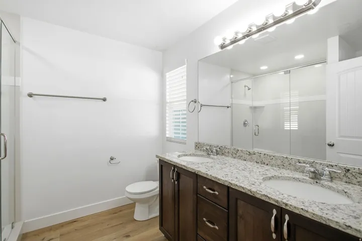 Primary bathroom with dual vanity and extra large shower with upgraded glass.