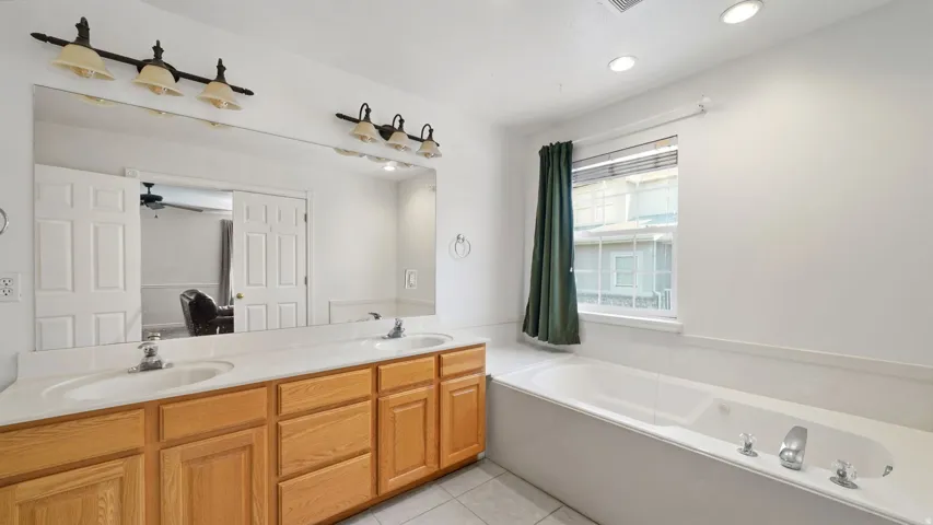 Master bathroom featuring dual sink vanity with wood cabinetry and an integrated soaking tub