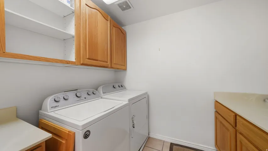 Laundry area featuring wood-finish cabinetry, built-in shelving, and a counter space with an integrated sink