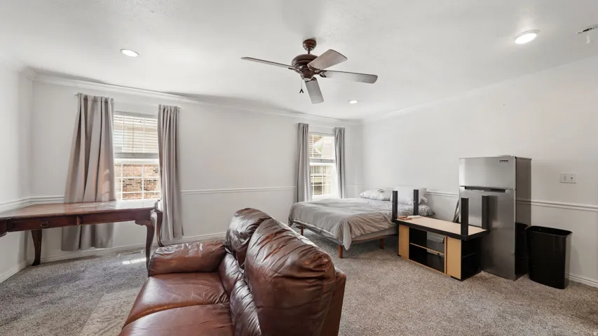 Master bedroom featuring white walls, recessed lighting, and a ceiling fan
