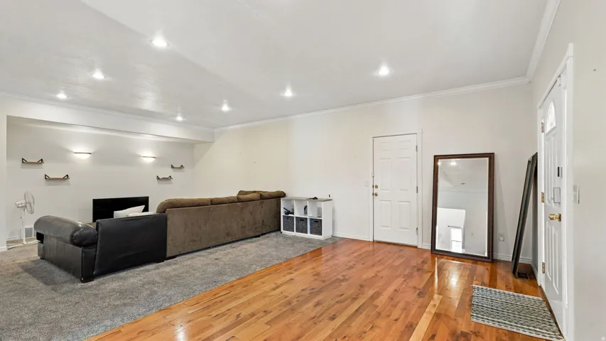 Recessed lighting, wood flooring, crown molding, wall-mounted shelving, white interior door