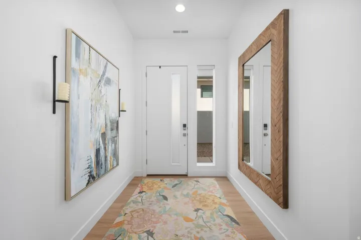 Entryway featuring wood-finish flooring, a contemporary door with a frosted glass insert, and a sidelight