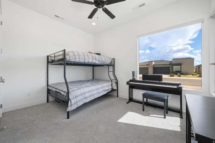 Recessed lighting, ceiling fan, expansive window, and light gray carpeting