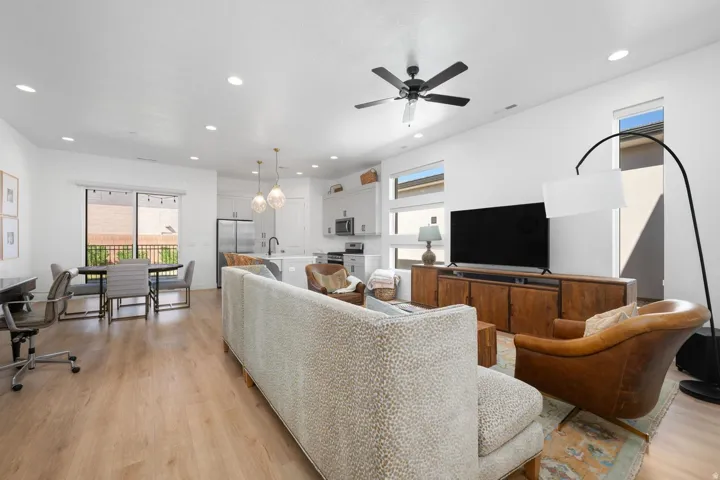 Open-concept living space with wood-finish flooring, recessed lighting, and a ceiling fan