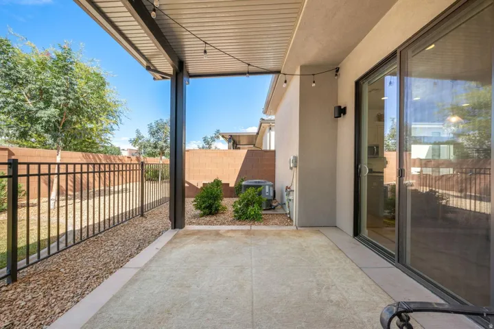 Covered patio featuring a solid roof, string lighting, and a sliding glass door