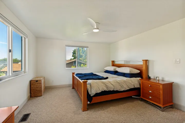 Carpeted flooring, white walls, and a ceiling fan with integrated lighting