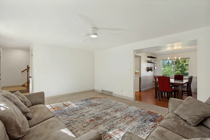 Open concept living area with light-colored carpeting