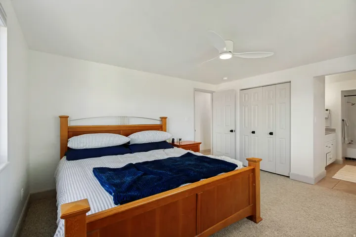 Wall-to-wall carpeting with a ceiling fan, dual bi-fold closet doors, and recessed lighting