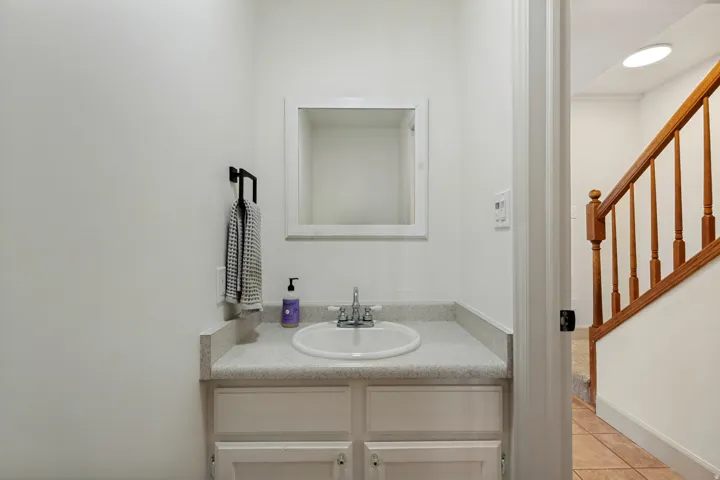 Vanity with an integrated sink, built-in cabinetry, and a framed mirror