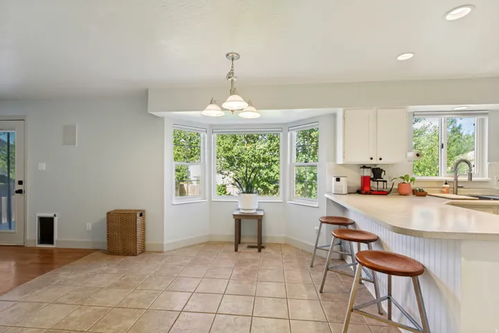 Kitchen with tiled flooring, white cabinetry, and a peninsula countertop with seating