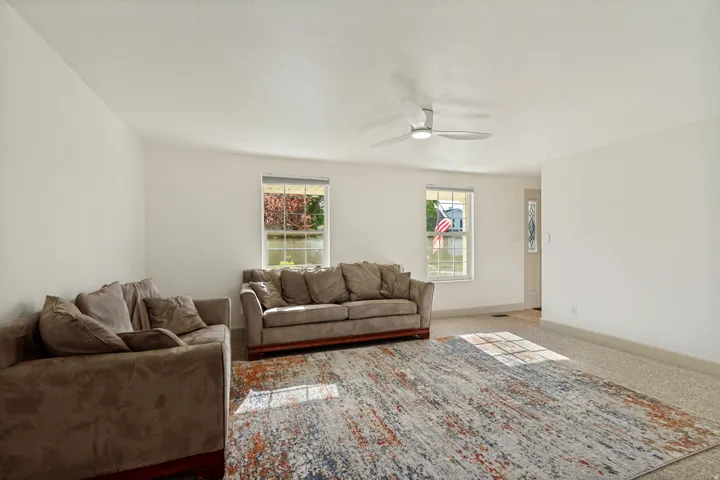 Recessed lighting, ceiling fan, multiple windows, front entry door with decorative glass inlay, light-toned carpet flooring