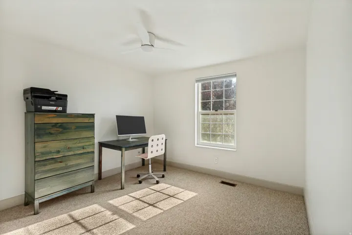 Wall-to-wall carpeting and a ceiling fan